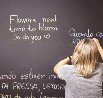 Child writing Spanish on  chalkboard